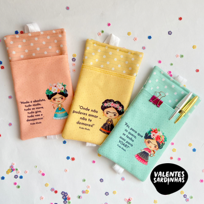 Três bolsas coloridas com ilustrações femininas e frases em português sobre fundo branco com confetes coloridos.