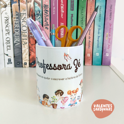Copo de metal branco com canetas e tesoura, texto 'professora Zé' e ilustrações de crianças, com livros ao fundo.