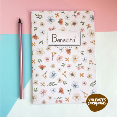 Agenda com capa floral e texto Benedita 2023-2024 ao lado de um lápis rosa