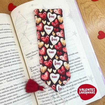 Marca-páginas tecido com corações e palavras em livro aberto