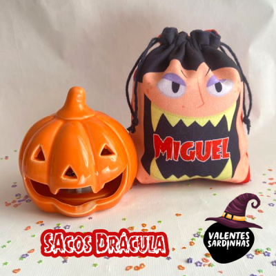 Saco de tecido com rosto monstruoso e saco abóbora decorativo em superfície branca com confetis