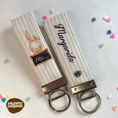 Porta-chaves de tecido com padrão riscado creme e branco com nomes Maria e Margarida e ilustração de coelho.