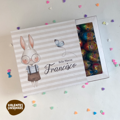 Caixa de Páscoa com orelhas de coelho e texto personalizado 'Feliz Páscoa Francisco' com ovos de chocolate coloridos