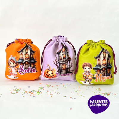Três saquinhos coloridos com temas de Halloween e nomes personalizados