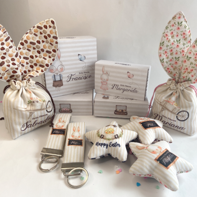 Produtos de Páscoa com orelhas de coelho, almofadas em forma de estrela e porta-chaves, em tons suaves e padrões riscados.