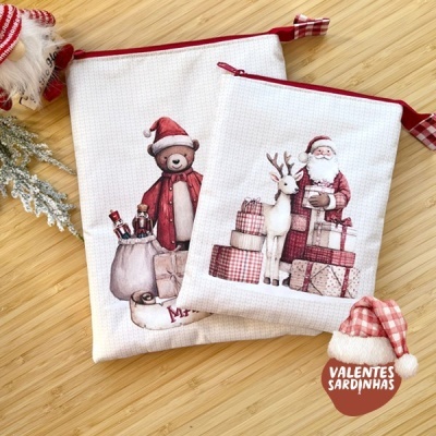 Duas bolsas de tecido com estampas de Natal sobre fundo de madeira