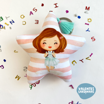 almofada em forma de estrela com desenho de menina e chaveiro tassel