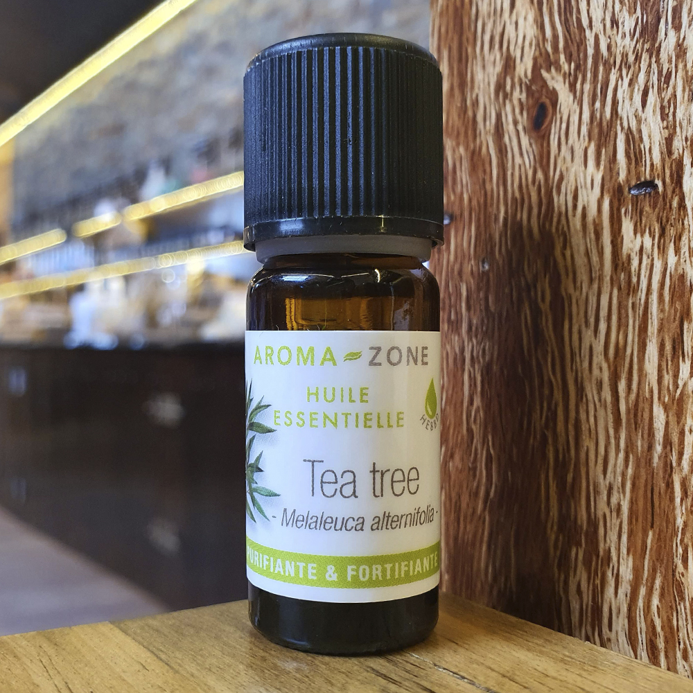 Óleo Essencial de Árvore-do-chá Frasco de óleo essencial Tea tree Aroma-Zone sobre superfície de madeira