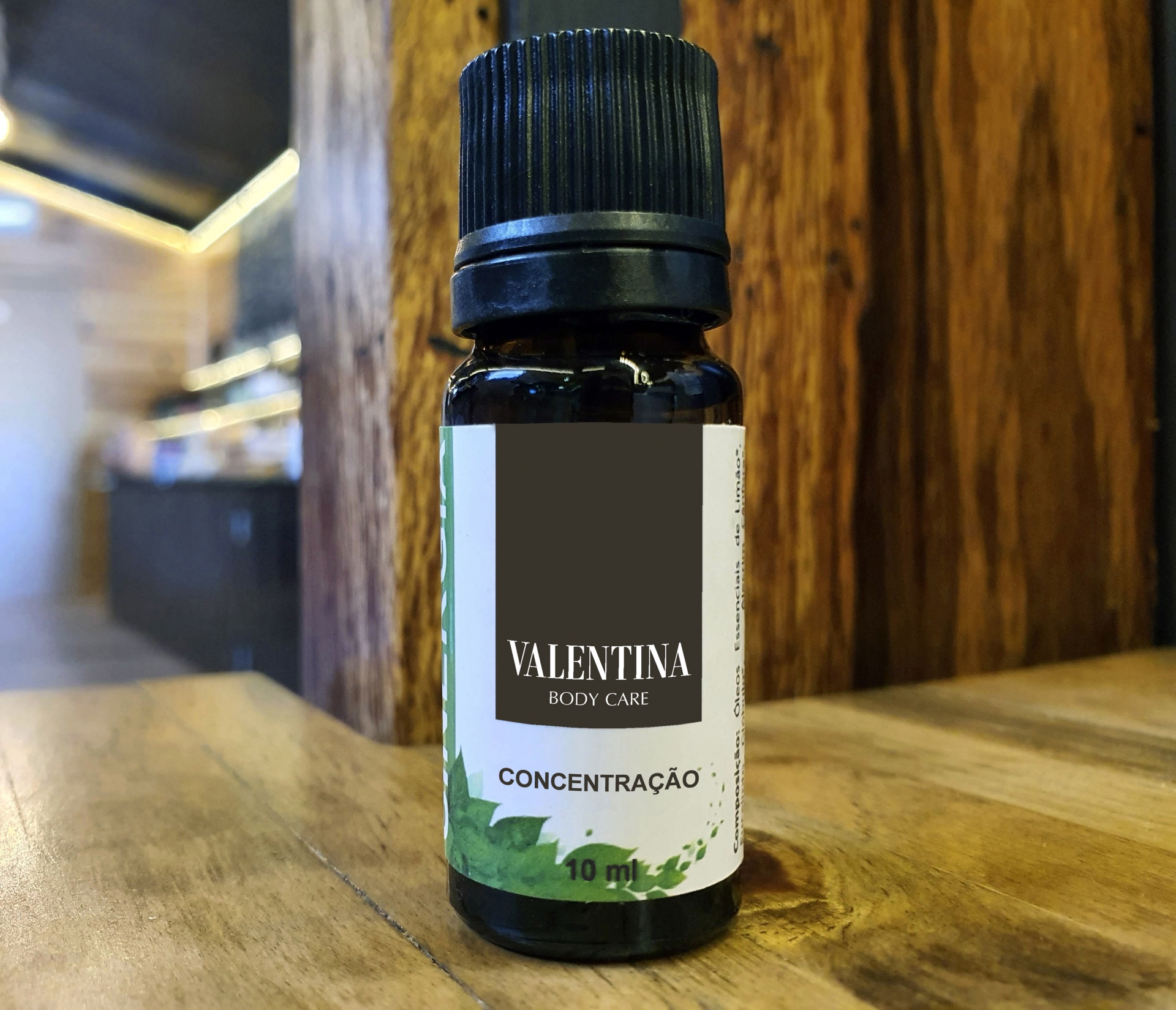 Sinergia Natural Concentração Frasco pequeno de vidro escuro com tampa preta e etiqueta branca com texto em preto, sobre mesa de madeira.