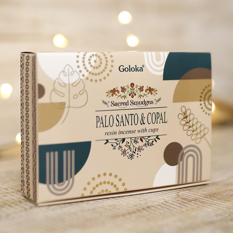 Pau Santo & Copal Maia - Copos de Incenso Sambrani Goloka Caixa de incenso Goloka Palo Santo & Copal com design geométrico em tons neutros sobre tecido claro.