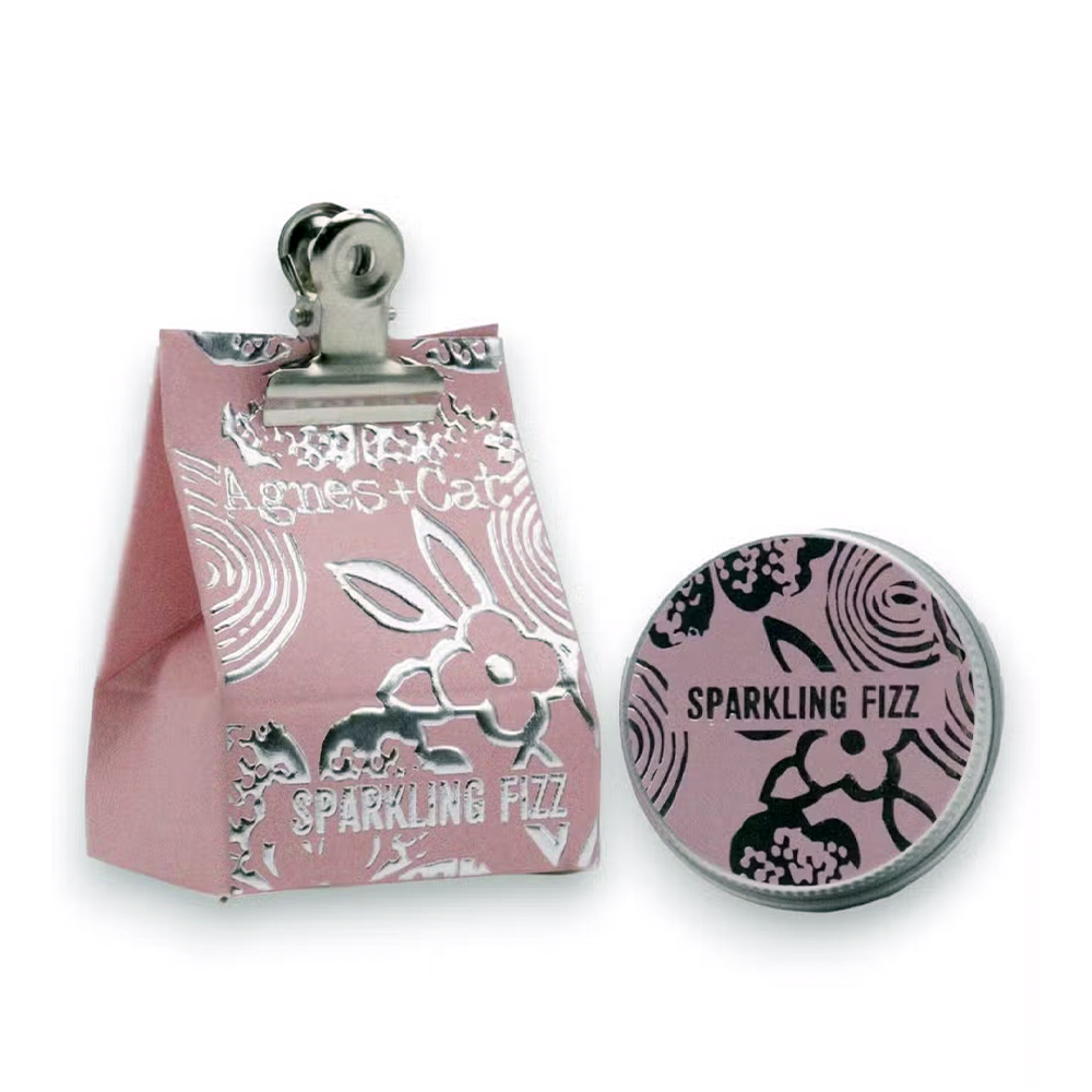 Bálsamo Labial Orgânico de Fizz Brilhante Conjunto de saco de papel rosa com clip e lata redonda rosa com texto e padrões florais