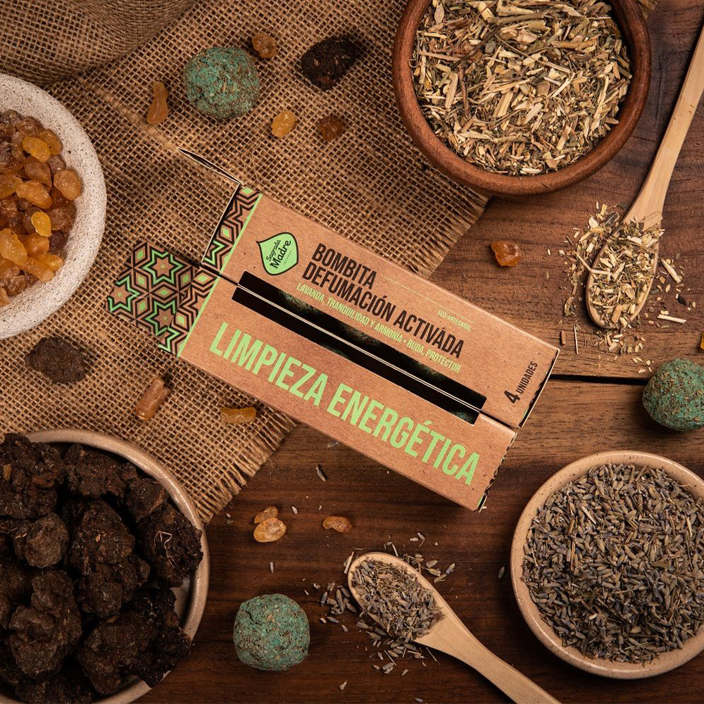 Bombitas Defumação Ativada Limpeza Energética - Sagrada Madre Caixa de bombita de defumação ativada em superfície de madeira com ervas secas e tecido rústico