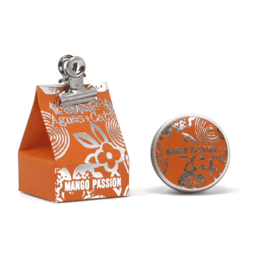Bálsamo Labial Orgânico de Manga & Maracujá Embalagem e lata laranja decoradas com motivo florido e texto Agnes+Cat e MANGO PASSION