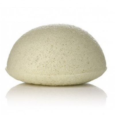 Konjac - esponja vegetal Esponja branca semi-circular porosa sobre superfície branca refletora