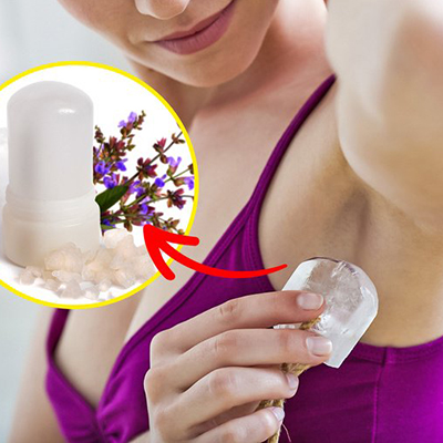 Como Escolher Um Desodorizante Natural? Mulher a aplicar desodorizante sólido com frasco branco e lavanda