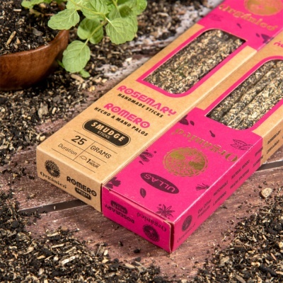 Palitos de defumação de alecrim em caixas coloridas sobre terra em superfície de madeira