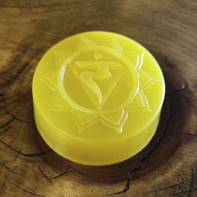 Disco amarelo com relevo de símbolo sobre superfície de madeira