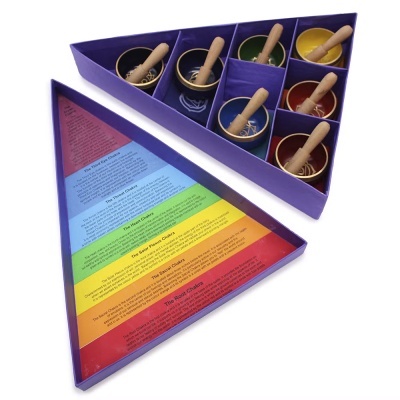 Conjunto de tigelas tibetanas coloridas com malhetas em caixa roxa com texto sobre chakras