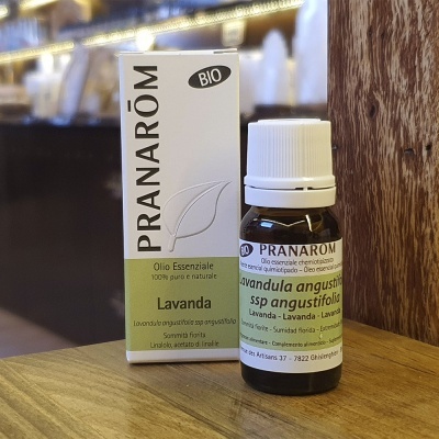 Frasco e caixa de óleo essencial Pranarôm de Lavanda em vidro âmbar com tampa branca sobre mesa de madeira