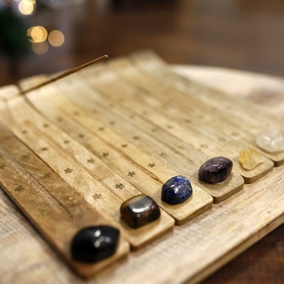 Incensários de madeira clara com pedras semi preciosas e incenso aceso