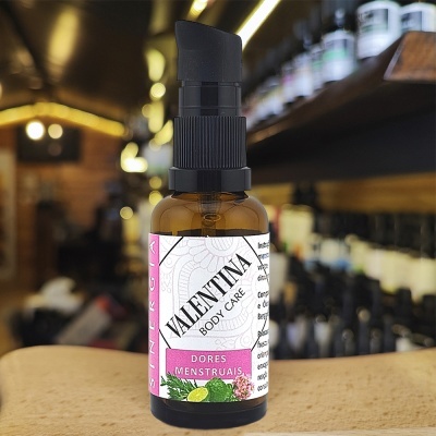 Frasco de vidro âmbar com doseador preto e rótulo branco e roxo de VALENTINA BODY CARE para dores menstruais