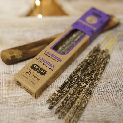 Caixa de incenso de lavanda com varetas e porta-incenso castanho em superfície clara