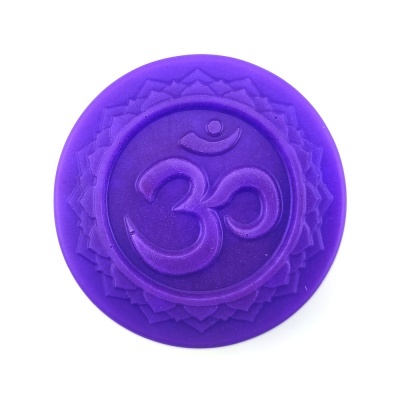 Disco roxo com símbolo Om em relevo no centro e padrão geométrico ao redor