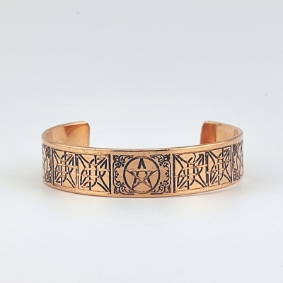Pulseira de cobre com gravuras de estrelas e linhas em relevo preto
