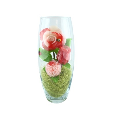 Vaso de vidro com flores artificiais rosas e detalhes verdes
