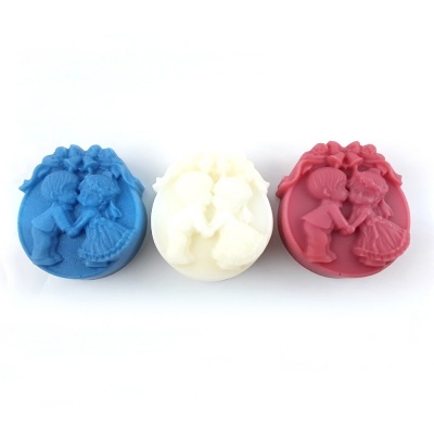 Três sabonetes redondos azul, branco e vermelho com relevo de crianças beijando-se