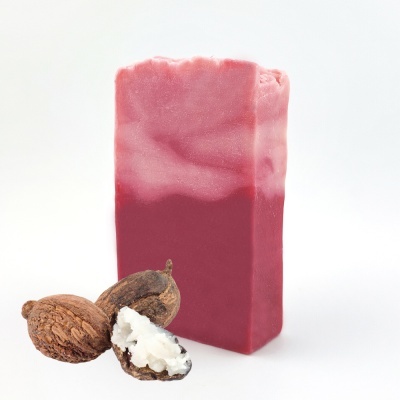 Sabonete rosa e vermelho com nozes de cacau abertas sobre fundo branco