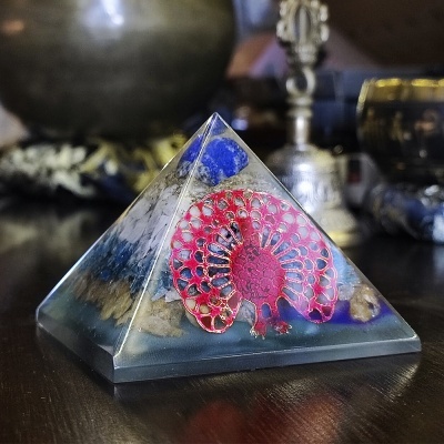 Pirâmide decorativa transparente com pavão vermelho e inclusões coloridas