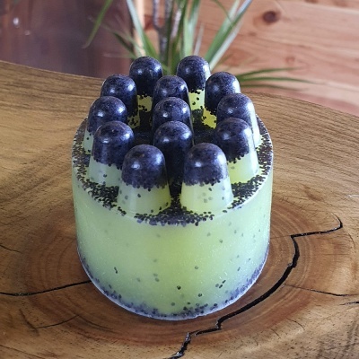 Bomba de banho amarela com detalhes pretos sobre madeira natural