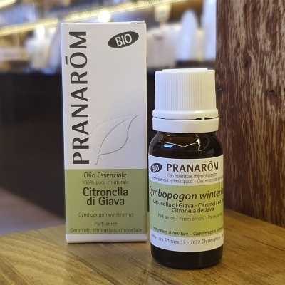 Frasco e embalagem de óleo essencial Pranarôm citronela di giava em superfície de madeira