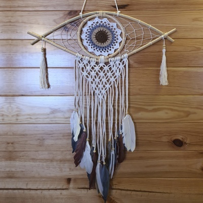 Apanhador de sonhos em forma de olho com penas penduradas