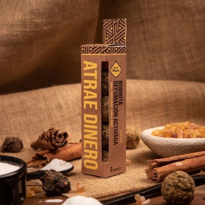 Caixa de incenso Atrae Dinero com especiarias e vela em fundo de juta