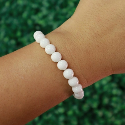 Pulseira de contas brancas redondas e brilhantes no pulso