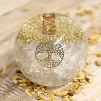 Orgonite esférico transparente com partículas douradas e espiral de metal
