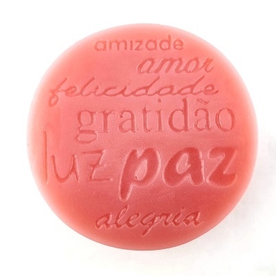 Sabonete redondo rosa com palavras gravadas na superfície