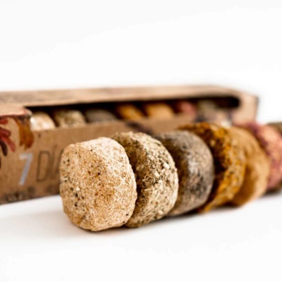 Discos de diferentes cores e texturas alinhados em frente a uma caixa de papelão