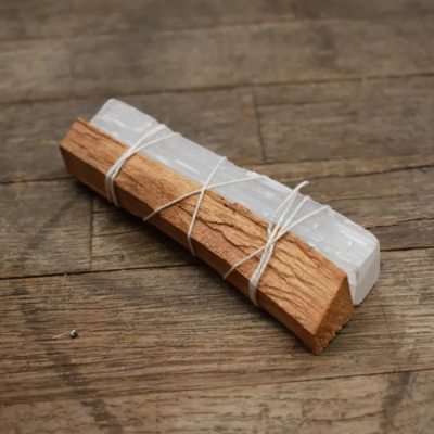 Bloco de madeira castanha e barra branca translúcida amarrados com fio branco sobre madeira