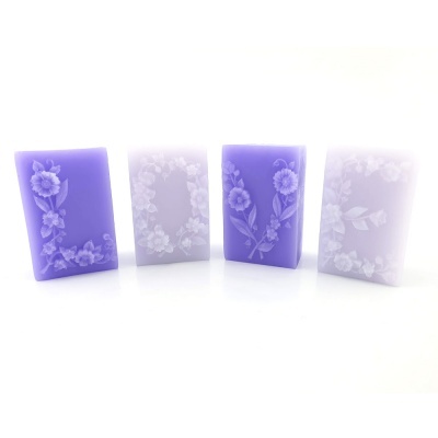 Velas decorativas retangulares lilás e branco com flores em relevo
