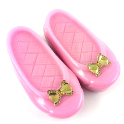 Sapatos de brinquedo cor-de-rosa com laços dourados
