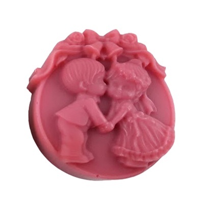 Objeto decorativo redondo cor-de-rosa com relevo de menino e menina a beijar-se