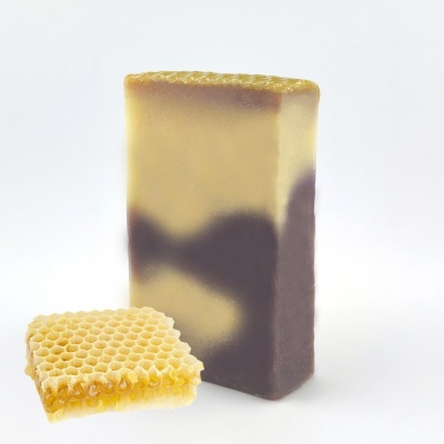 Sabonete retangular com camadas amarela e castanha, peça de favo de mel ao lado, fundo branco