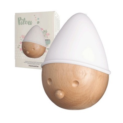 Difusor de aroma Pilou em madeira clara e plástico branco, com embalagem ao fundo