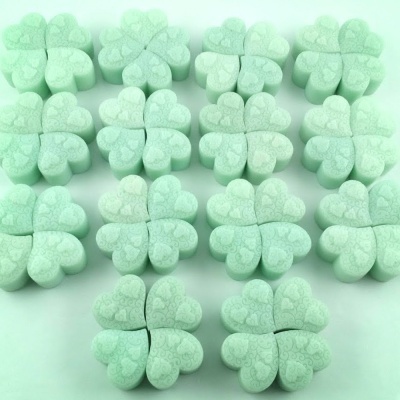 Esponjas de maquiagem verdes em forma de trevo de quatro folhas com textura de corações