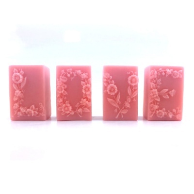 Sabonetes rosa com flores em relevo formando a palavra LOVE sobre fundo branco