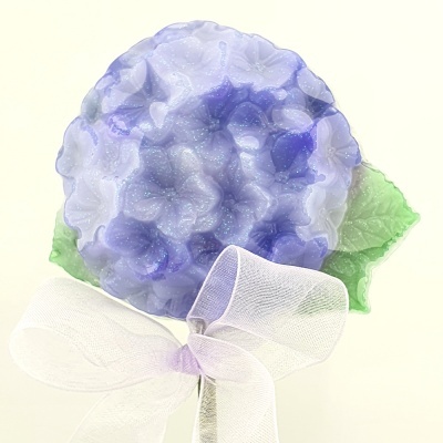 Broche flor hortênsia lilás com folhas verdes e fita branca