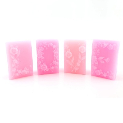 Quatro sabonetes rosa com padrões florais brancos